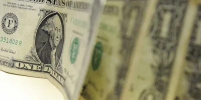 Dólar abre em queda de 0,3%, de olho na produção industrial