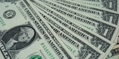 Dólar desacelera alta e opera volátil com exterior, fiscal e greve dos caminhoneiros