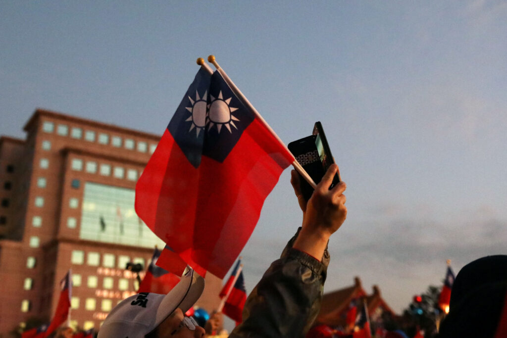 A supporter of Kuomintang party's presidential candidate Han Kuo-yu holds Taiwanese flags before an election rally in Taipei