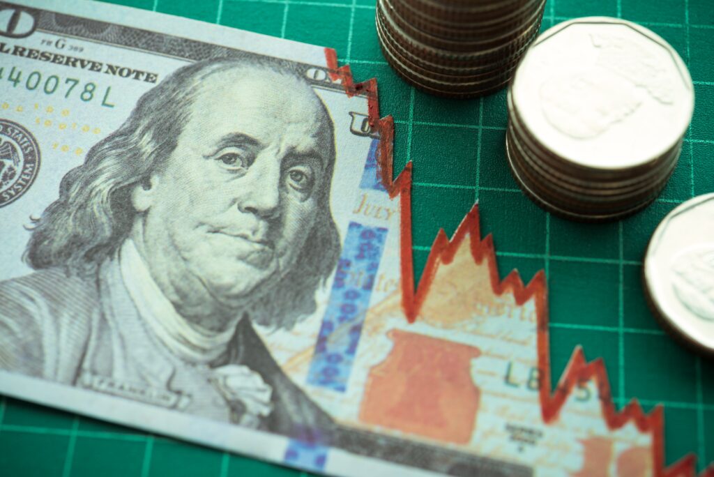 Imagem mostra uma nota de um dólar com gráfico quebrando e moedas ao lado de um tabuleiro verde, demonstrando a crise nos bancos americanos. cpts11 mcci11