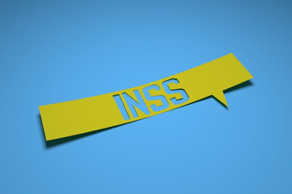 INSS escrito em papel amarelo com fundo azul